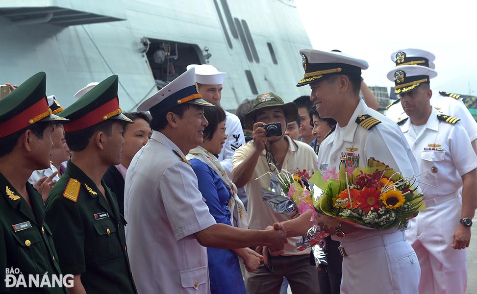Đại diện Hải quân nhân dân Việt Nam (trái) tặng hoa chúc mừng Đại tá Lê Bá Hùng và các thủy thủ đoàn.  