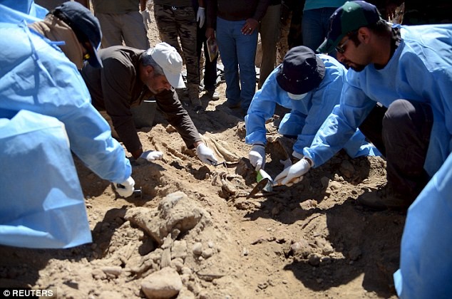 Các chuyên gia Iraq khai quật ngôi mộ chôn thi thể những nạn nhân bị IS hành hình. Ảnh: Reuters