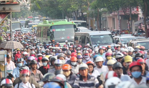 Motorcycles, buses, and cars cause traffic congestion on a road in Ho Chi Minh City.