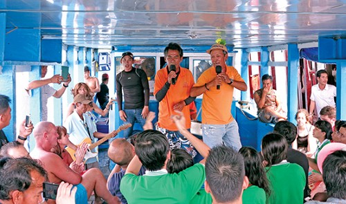 Tourists, including foreigners, on board a boat off Nha Trang City, the capital of the south-central province of Khanh Hoa, are entranced by a 