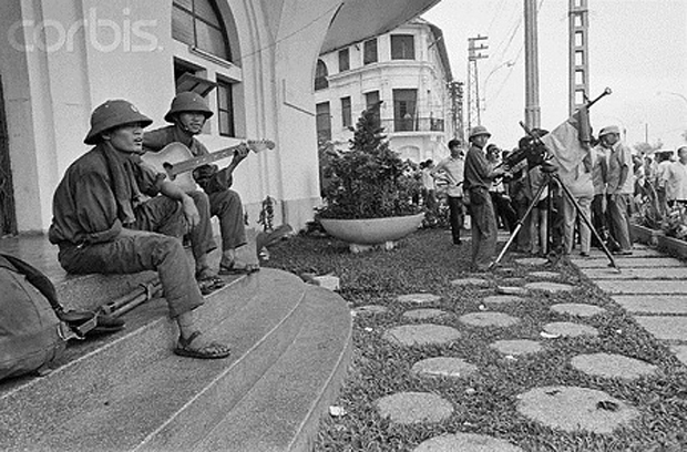 Trong niềm vui phơi phới, hai chiến sĩ giải phóng quân đàn hát ngay trên bậc thềm của khách sạn Majestic nằm bên sông Sài Gòn. (Ảnh: Bettmann/Corbis)