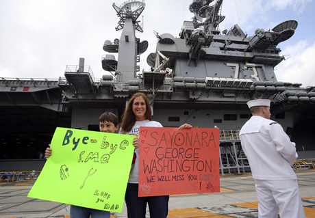 Gia đình một thủy thủ trên tàu USS George Washington viết biểu ngữ tạm biệt tại căn cứ Yokosuka, Nhật, gần Tokyo. (Ảnh: JT)