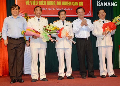 Municipal Party Committee Secretary Tran Tho (second, right) and People’s Committee Chairman Huynh Duc Tho (first, left) presenting flowers to the newly-appointed police officers