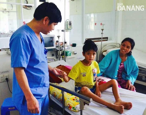 A doctor (left) from the hospital examining Quoc (centre)