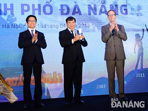 Chairman Tho (middle) receiving the souvenir cup in recognition of Da Nang’s top position in the PCI 2014 on behalf of the local leaders and people