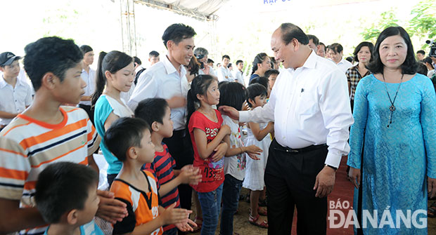 Phó Thủ tướng Nguyễn Xuân Phúc ân cần thăm hỏi, động viên các cháu thiếu niên, nhi đồng Làng Trẻ em SOS Đà Nẵng. 		 Ảnh: VĂN NỞ