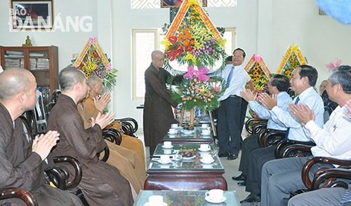 Chairman Hung (right) presenting a flower basket to a representative of the city’s Buddhist Sangha