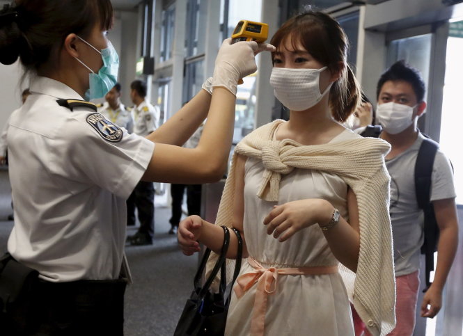 Một nữ du khách từ Hàn Quốc bị kiểm tra thân nhiệt tại sân bay Hong Kong Ảnh: Reuters