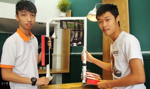 e Nhat Hung (L) and Nguyen Tien Dung pose beside their solar traffic light system. Tuoi Tre