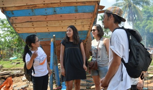 A Vietnamese student (first left) is seen providing guidance for a group of foreign tourists in the Kim Bong carpentry village in Hoi An City