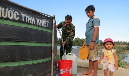 A soldier extracts clean water from a large tank to provide it for residents in Ninh Thuan Province 