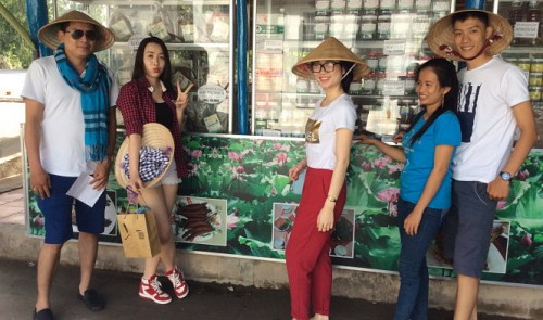 Young tourists pose in front of the specialty-souvenir shop at the Tram Chim National Park