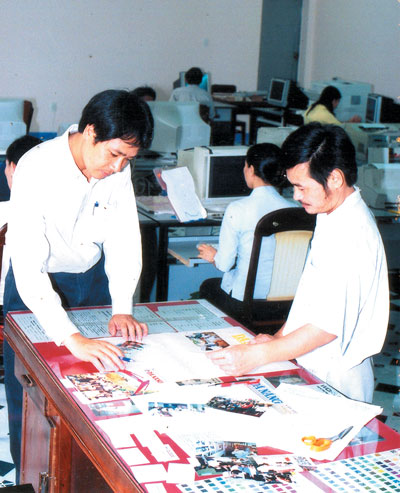 Họa sĩ Lê Gia Thụy (phải) và anh Quốc Trung trong một lần hội ý trang bìa cho một ấn phẩm của báo.