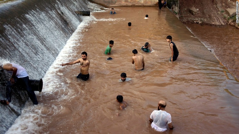 Thanh niên Pakistan giải nhiệt trên một con sông ở Islamabad