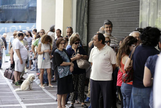 Người dân xếp hàng bên ngoài một ngân hàng ở trung tâm Athens chờ rút tiền, ngay cả khi ngân hàng này không mở cửa. 			          Ảnh: AP