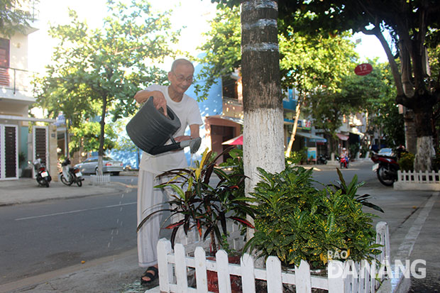 Mỗi ngày 2 lần, ông Lê Công Thạnh cần mẫn mang nước ra tưới bồn hoa trước nhà. Ảnh: T.Y