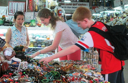 Foreign tourists buying souvenirs at a local market 