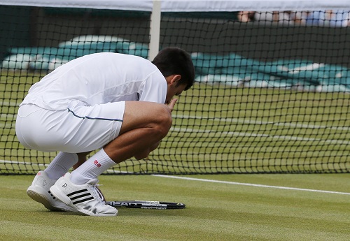 Djokovic hôn mặt cỏ ở sân Số một sau khi giành chiến thắng. Ảnh: Reuters.