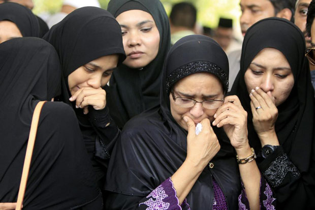 Gia đình của Nur Shazana, một thành viên phi hành đoàn thiệt mạng, đau buồn tại lễ tang ở Putrajaya, Malaysia, ngày 22-8-2014. 			         Ảnh: AP