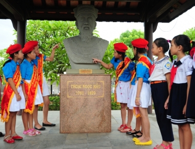  Local pupils beside the statute of the General Thoai Ngoc Hau ( Photo: nhandan.com.vn)