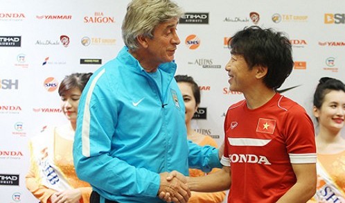 Viet Nam's coach Toshiya Miura (R) shakes hands with his Manchester City counterpart Manuel Pellegrini at the end of a press conference in Ha Noi on July 26, 2015.