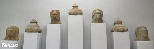 A collection of statues’ heads and the top of Cham towers