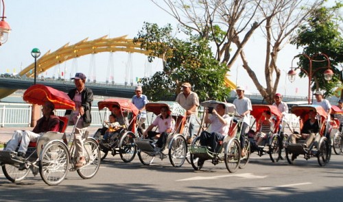 Foreign visitors travel on cyclos along the iconic Han River in Da Nang