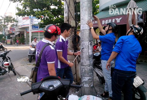 Đoàn Thanh niên quận Hải Châu tham gia xóa quảng cáo, rao vặt sai quy định. Ảnh: S.TRUNG