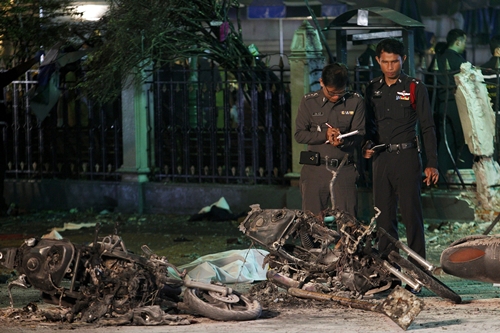 Các chuyên gia kiểm tra phần còn lại của một xe môtô bị phá hủy trong vụ đánh bom tối 17/8. Ảnh: Reuters.