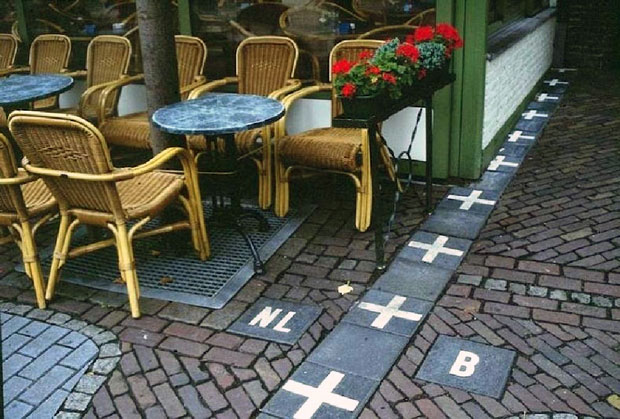 Đường biên giới được đánh dấu cộng (+), bên phải là Bỉ (B - tiếng Hà Lan: België) và bên trái là Hà Lan (NL - tiếng Hà Lan: Nederland). Ảnh: Amusing Planet.