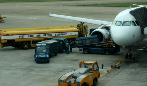 Different vehicles provide ground services to a plane at Tan Son Nhat International Airport 