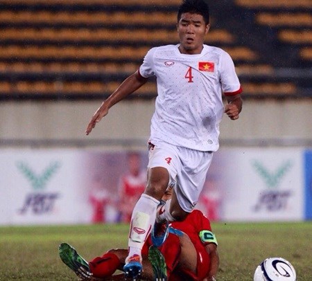 Ha Duc Chinh of Vietnam passes a Myanmar player during the regional U19 championship in Laos. Vietnam won 2-0. Photo: zing.vn