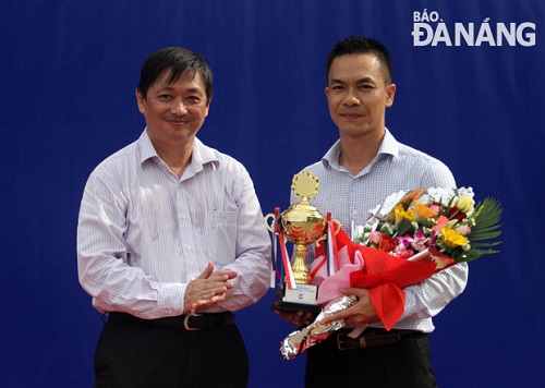 Municipal People's Committee Vice Chairman Dang Viet Dung presenting flowers and a memento to a sponsor of the event.