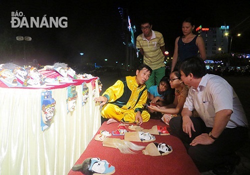 Visitors being introduced to Tuong mask drawing on the sidelines of a Tuong street performance