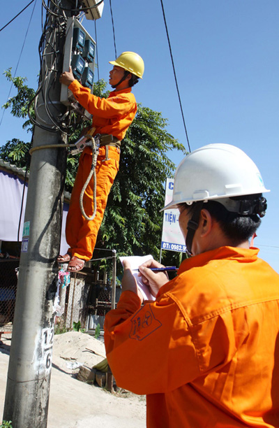 Công nhân Công ty điện lực Huyện Gio Linh (Quảng Trị) kiểm tra công tơ điện định kì. Ảnh: Hồ Cầu-TTXVN