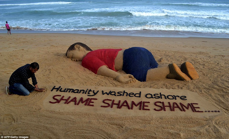 Indian artist Sudarsan Pattnaik works on a sand sculpture depicting drowned Syrian boy Aylan Kurdi, three, at Puri beach, some 65 kilometers from Bhubaneswar in eastern India  