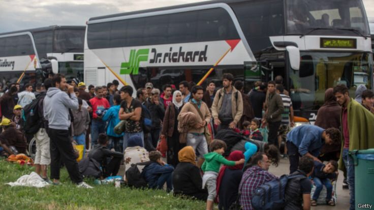 Người di cư chờ lên xe buýt tới biên giới Hungary - Áo