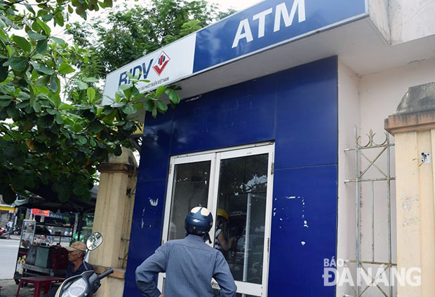 Nhiều chủ thẻ cho rằng nên bỏ phí từ dịch vụ rút tiền tự động. Trong ảnh: Khách hàng đến rút tiền tại máy ATM trước cổng khu công nghiệp Hòa Khánh.
