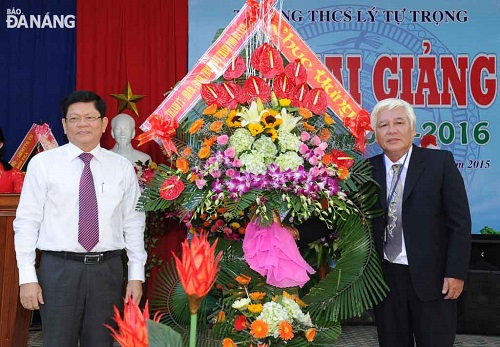  Municipal Party Committee Deputy Secretary Vo Cong Tri (left) presenting flowers to a representative from Ly Tu Trong Junior High Schoo