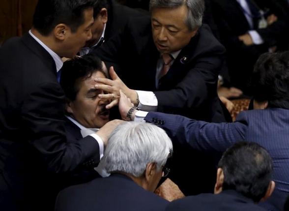 Các nghị sĩ đối lập bao vây nhằm ngăn cản Chủ tịch và Phó chủ tịch Ủy ban đặc biệt về an ninh của Thượng viện Nhật Bản trước cuộc bỏ phiếu thông qua dự luật an ninh ngày 17-9-2015. Ảnh: Reuters