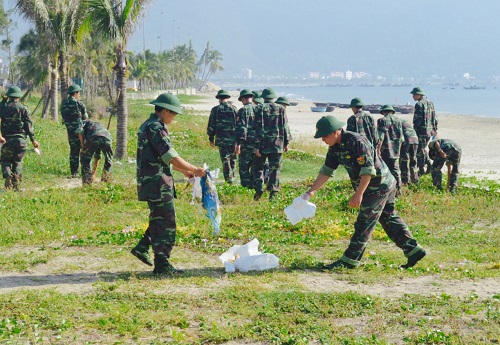 Local armed forces collecting rubbish at a local beach