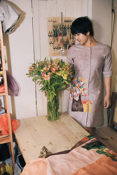 A model wearing a modern ao dai featuring hand-drawn patterns