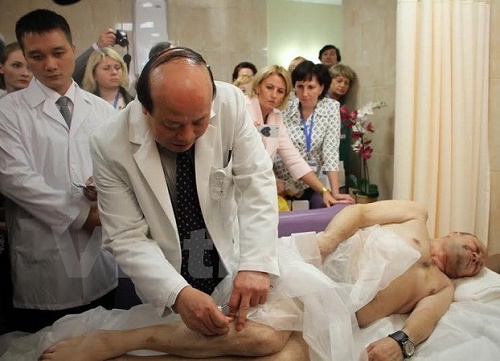 Director of the National Hospital of Acupuncture Nguyen Huu Thanh applies acupuncture on a Russian patient. (Photo: VNA)