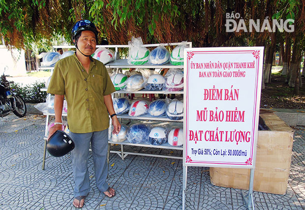 Một người dân mua mũ bảo hiểm đạt chất lượng tại điểm bán của UBND quận Thanh Khê. 
