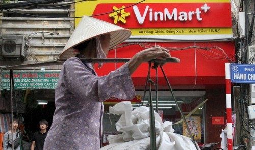 A woman walks past a Vinmart shop in Ha Noi, October 12, 2015. Reuters