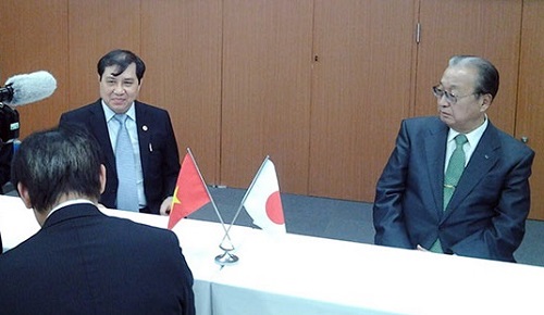 Chairman Duc Tho (left) and a representative from Japan