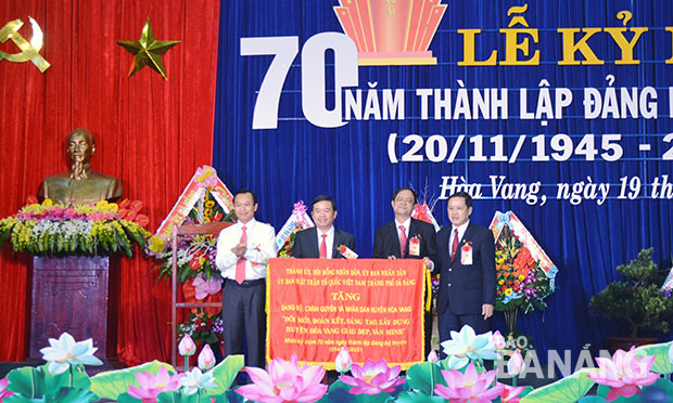 Bí thư Thành ủy Nguyễn Xuân Anh trao tặng Đảng bộ, chính quyền và nhân dân huyện Hòa Vang bức trướng mang dòng chữ “Đổi mới, đoàn kết, sáng tạo, xây dựng huyện Hòa Vang giàu đẹp, văn minh”.   Ảnh: Đoàn Lương