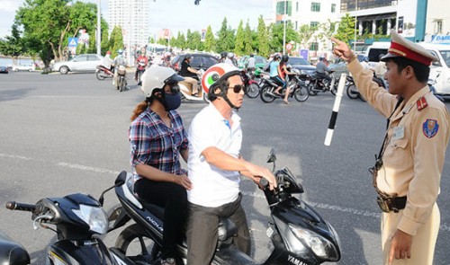 A traffic police officer in Da Nang is seen show ways to a driver.