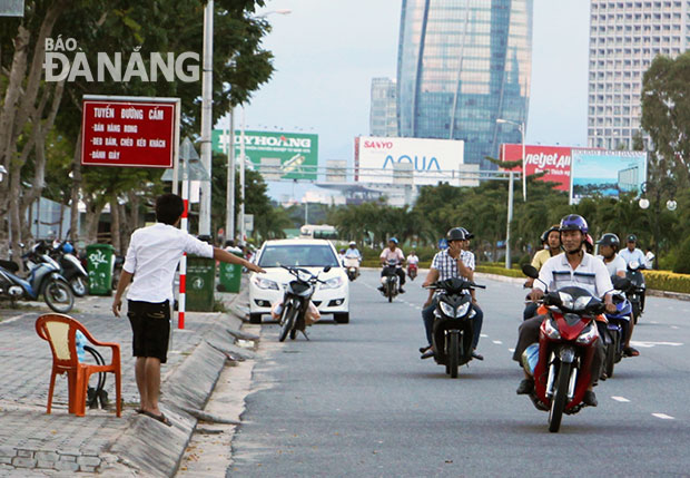 Bất chấp biển cấm chèo kéo khách, nhân viên quán nhậu Khanh đứng vẫy khách vào nhậu trên tuyến đường Phạm Văn Đồng. 