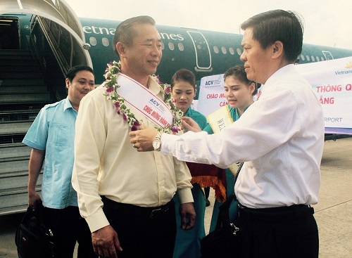 A representative from the Da Nang International Airport presenting flowers to the 6-millionth passenger, Mr Pham Van Tai 